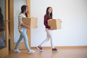 two-women-carrying-cardboard-boxes