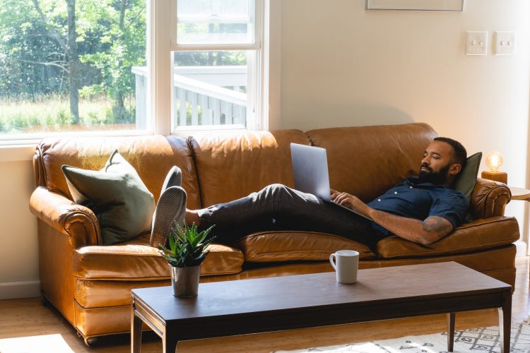 a man sitting on a couch using a laptop