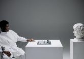 a-man-playing-chess-against-a-head-statue