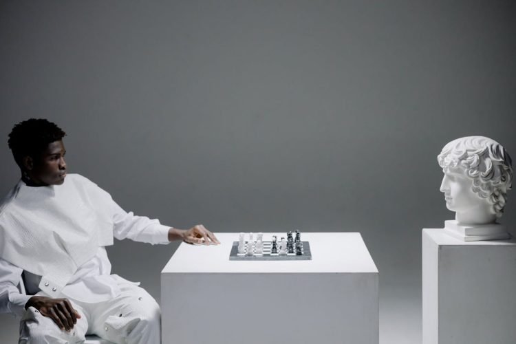 a-man-playing-chess-against-a-head-statue